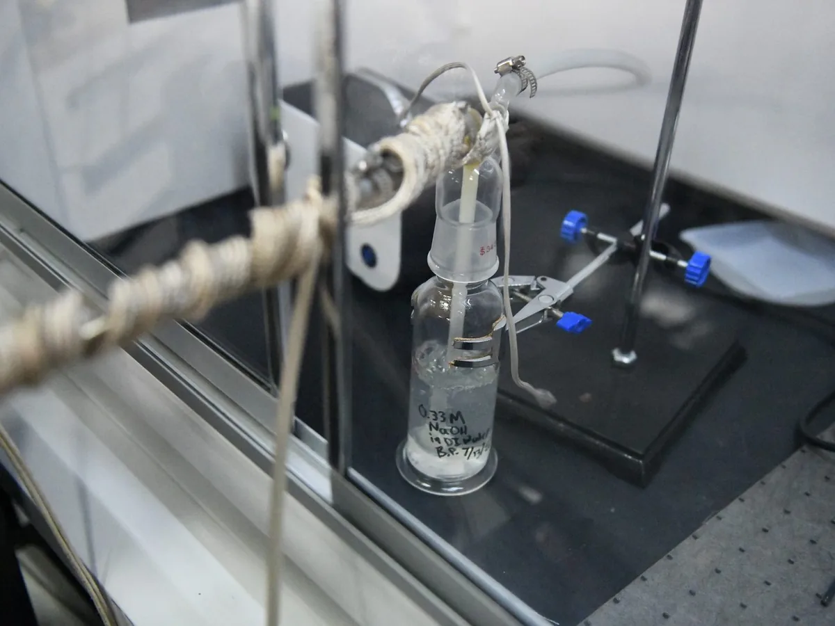 Glass bubbler and a heat-traced line on a bench inside a hood